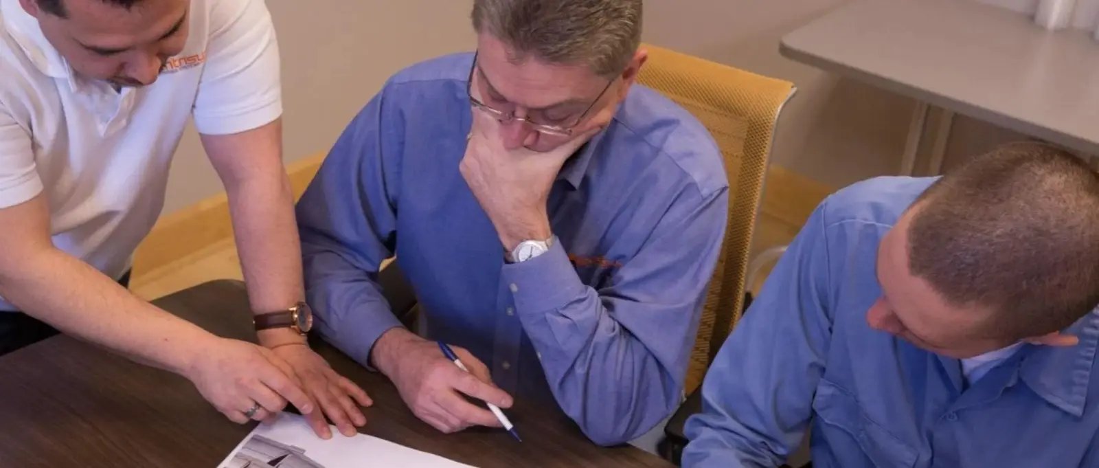 Centrisys technicians collaborate and review blueprints for decanter centrifuge repair.
