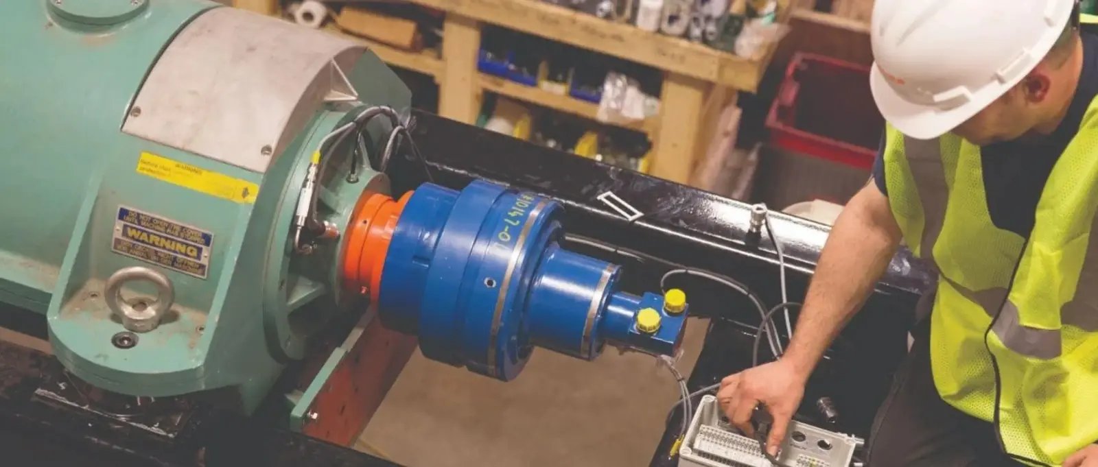 A technician services a decanter centrifuge and hydraulic drive at a certified repair facility.