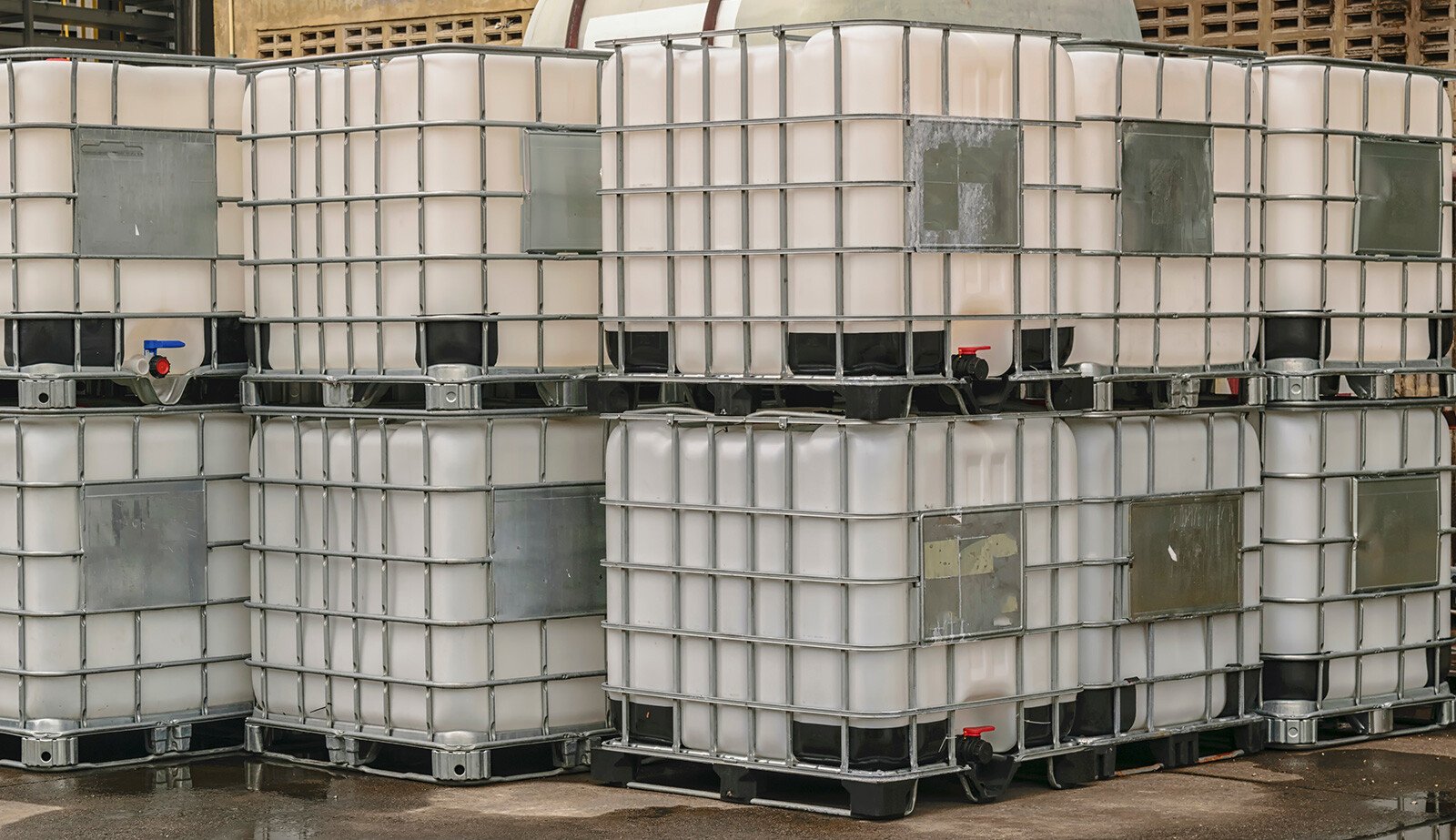 A stack of polymer bins set outside on pavement.